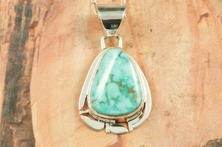 Genuine Manassa Turquoise set in Sterling Silver Pendant. This Turquoise is also referred to as King�s Manassa Turquoise. The Manassa Turquoise mine is located in Manassa, Conejos County, Colorado. Created by Navajo Artist Phillip Sanchez. Signed by the artist. Free 18